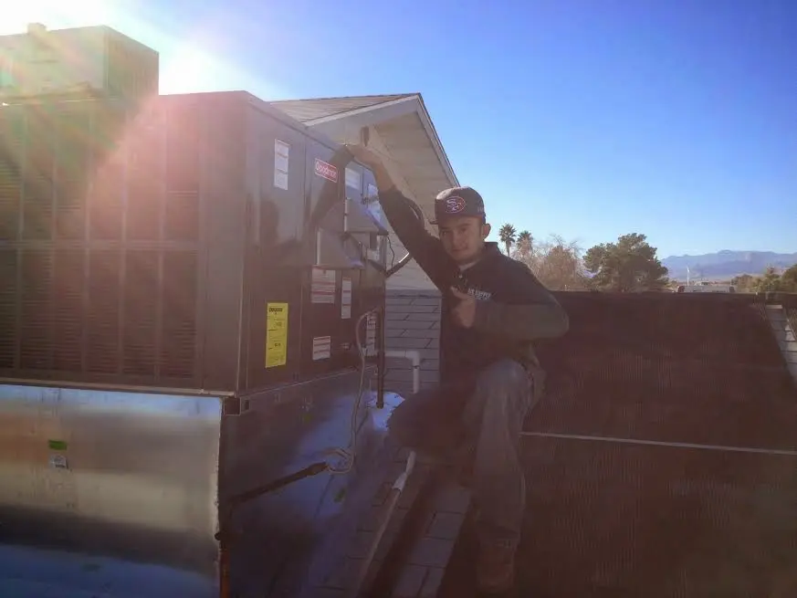HVAC technician performing Boiler Repair on a rooftop unit in Schiller Park